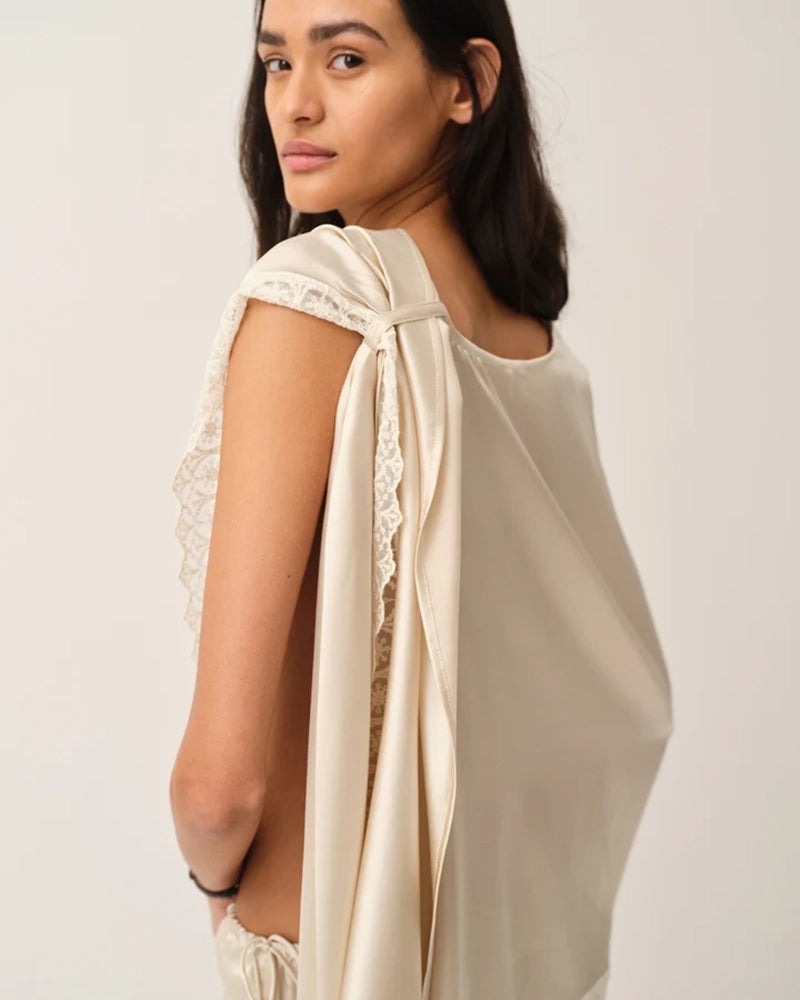 Elegancka, jedwabna peleryna Cata The Garment o asymetrycznym fasonie. Zebrana na lewym ramieniu. Wykończona zmysłową koronką. Wykonana z lejącej, jedwabnej tkaniny.