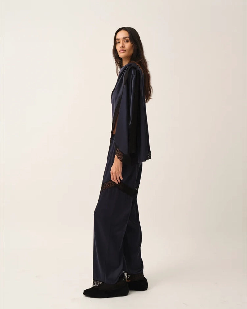 Elegancka, jedwabna peleryna Cata The Garment o asymetrycznym fasonie. Zebrana na lewym ramieniu. Wykończona zmysłową koronką. Wykonana z lejącej, jedwabnej tkaniny.