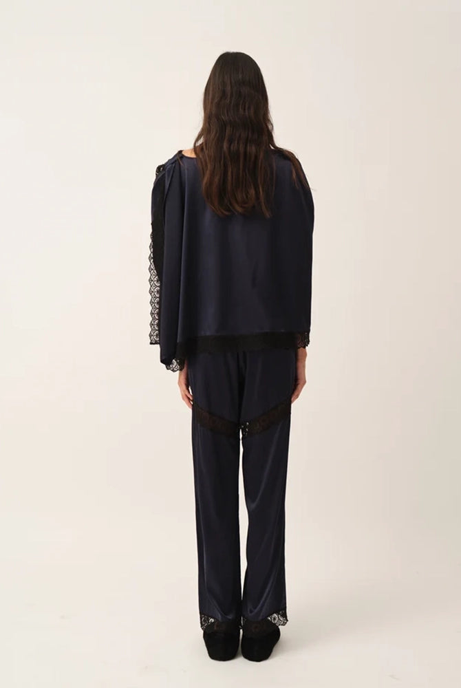 Elegancka, jedwabna peleryna Cata The Garment o asymetrycznym fasonie. Zebrana na lewym ramieniu. Wykończona zmysłową koronką. Wykonana z lejącej, jedwabnej tkaniny.