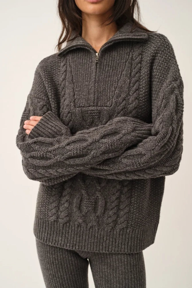 Długi, gruby sweter Como Zip The Garment z rozpinanym golfem i pięknym, warkoczowym wzorem. Posiada opadające ramiona, prosty krój, luźny fason i długie rękawy. Wykończony ściągaczami. Sweter ma długość za biodra. Wykonany z bardzo miękkiej i szlachetnej mieszanki wełny i kaszmiru. Idealny do legginsów, wąskich spodni lub zwiewnej spódnicy. 