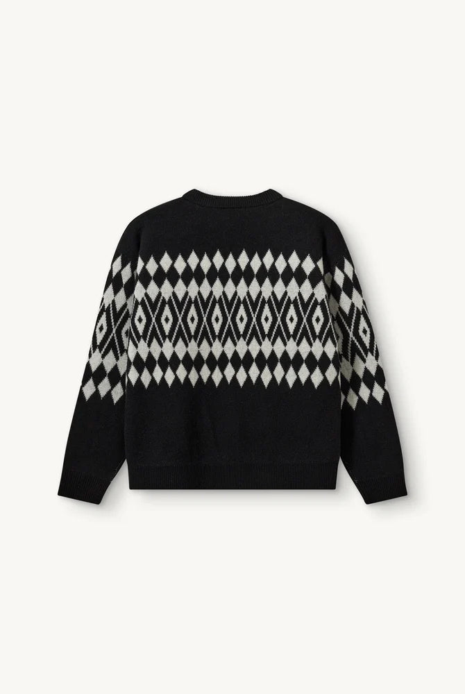 Luźny, wełniany sweter Faroe The Garment w geometryczny, kontrastowy wzór. Posiada okrągły dekolt, opadające ramiona i długie rękawy. Wykończony ściągaczami. Sweter ma prosty krój i długość za biodra. Wykonany z grubej i miękkiej, wełnianej dzianiny z kaszmirem