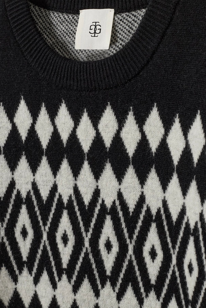 Luźny, wełniany sweter Faroe The Garment w geometryczny, kontrastowy wzór. Posiada okrągły dekolt, opadające ramiona i długie rękawy. Wykończony ściągaczami. Sweter ma prosty krój i długość za biodra. Wykonany z grubej i miękkiej, wełnianej dzianiny z kaszmirem