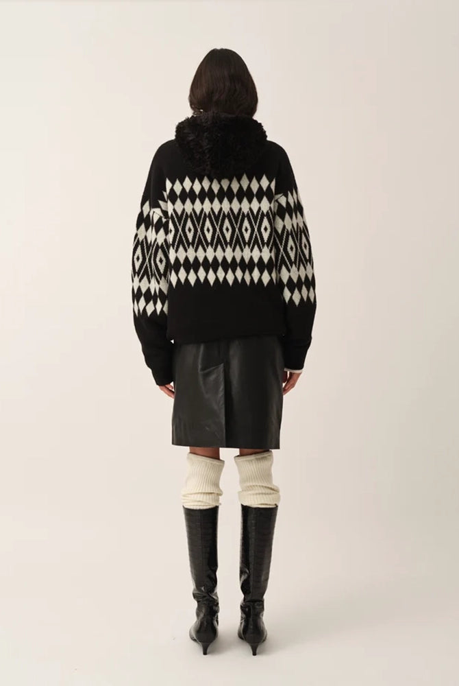 Luźny, wełniany sweter Faroe The Garment w geometryczny, kontrastowy wzór. Posiada okrągły dekolt, opadające ramiona i długie rękawy. Wykończony ściągaczami. Sweter ma prosty krój i długość za biodra. Wykonany z grubej i miękkiej, wełnianej dzianiny z kaszmirem
