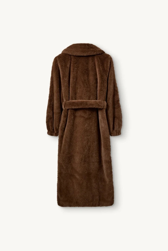 Długi, futrzany płaszcz Bianchi The Garment o szlafrokowym fasonie. Posiada dekolt w kształcie litery V i duży kołnierz. Rękawy płaszcza zakończone są elastycznymi ściągaczami. Wiązany w talii za pomocą grubego paska. Płaszcz ma dwie, boczne kieszenie. Posiada długość przed kostki. Wykonany z tkaniny z recyclingu.