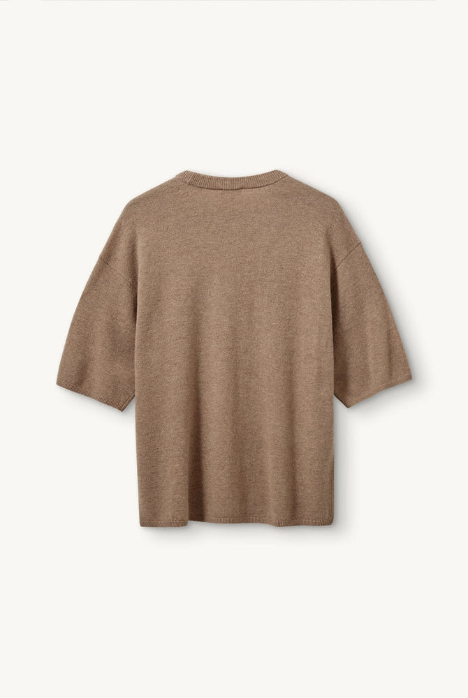 Oversizowy, dzianinowy t-shirt Como The Garment z okrągłym dekoltem i krótkim, luźnym rękawem o długości do łokcia. Posiada prosty krój. Wykonany z bardzo miękkiej, naturalnej dzianiny z wełną i kaszmirem. To minimalistyczna i ponadczasowa bluzka, która sprawdzi się w codziennych stylizacjach. Połącz ją z jeansami, spodniami garniturowymi czy bermudami