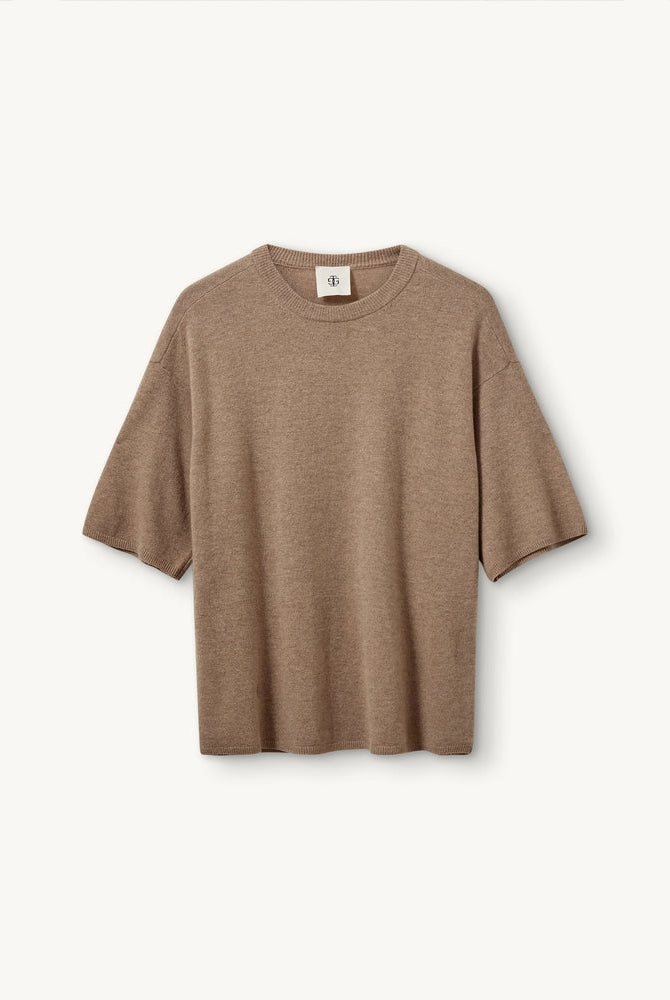 Oversizowy, dzianinowy t-shirt Como The Garment z okrągłym dekoltem i krótkim, luźnym rękawem o długości do łokcia. Posiada prosty krój. Wykonany z bardzo miękkiej, naturalnej dzianiny z wełną i kaszmirem. To minimalistyczna i ponadczasowa bluzka, która sprawdzi się w codziennych stylizacjach. Połącz ją z jeansami, spodniami garniturowymi czy bermudami