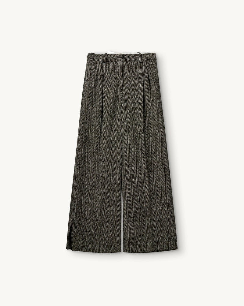 Szerokie, garniturowe spodnie York The Garment z wysokim stanem, zakładkami i długą, prostą nogawką z rozcięciami u dołu. Wykonane z teksturalnej tkaniny z wełną we wzór w jodełkę. Idealne do mokasynów i luźnego swetra lub przylegającego t-shirtu