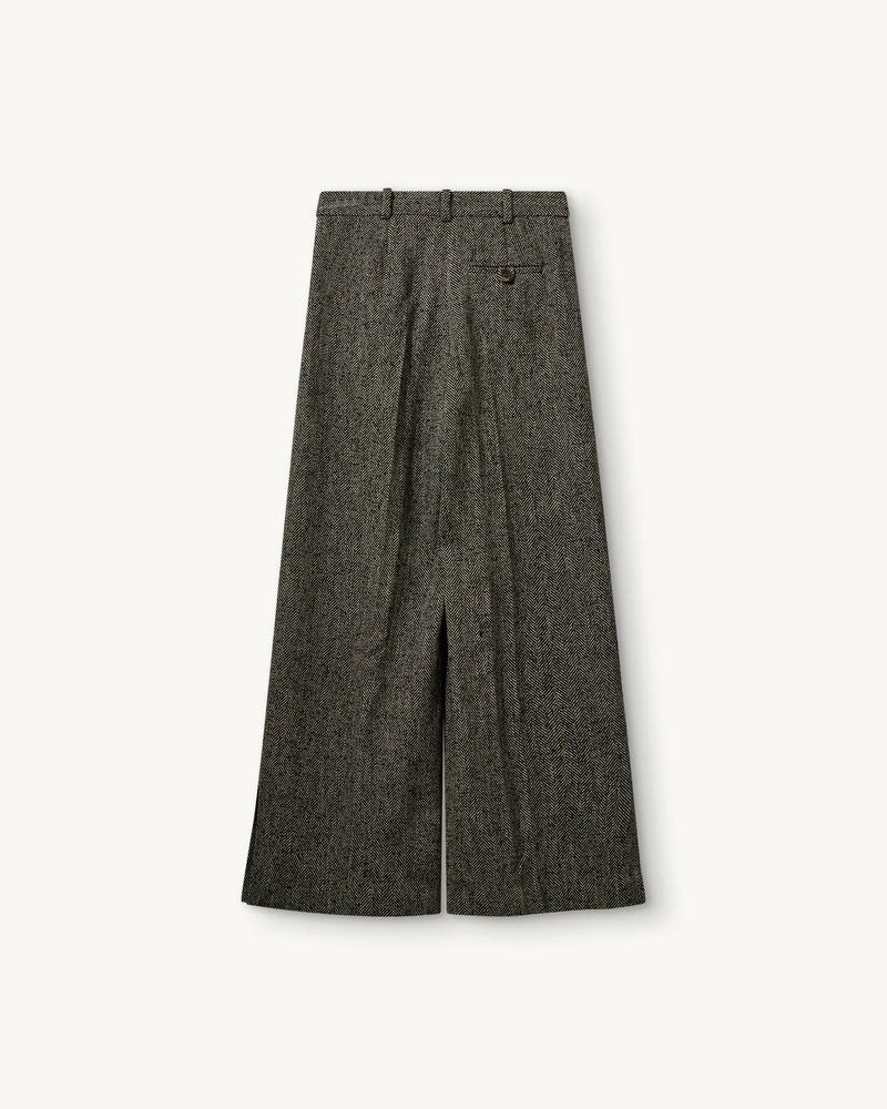 Szerokie, garniturowe spodnie York The Garment z wysokim stanem, zakładkami i długą, prostą nogawką z rozcięciami u dołu. Wykonane z teksturalnej tkaniny z wełną we wzór w jodełkę. Idealne do mokasynów i luźnego swetra lub przylegającego t-shirtu