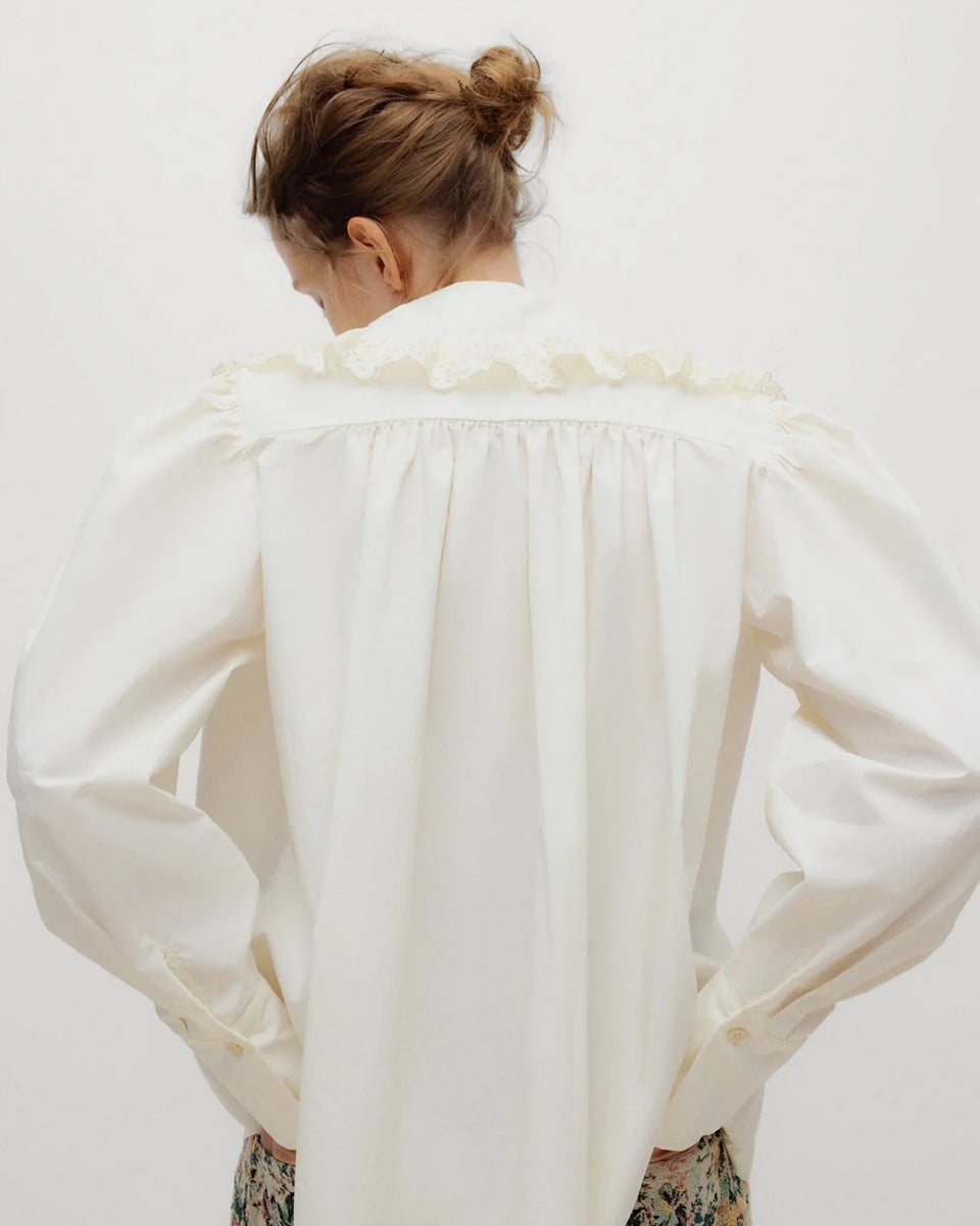 Romantyczna bluzka Vega TNS Whisper White wykonana z miękkiej, przewiewnej bawełny. Wyróżnia się swobodnym krojem oraz eleganckim dekoltem w kształcie litery V, wykończonym delikatnymi falbanami, które dodają całości faktury i ponadczasowej kobiecości. Delikatnie marszczone ramiona oraz obszerne długie rękawy zakończone dopasowanymi mankietami nadają sylwetce wdzięku. Bluzka doskonale sprawdzi się w codziennych stylizacjach, jak i podczas bardziej uroczystych okazji.
-Dekolt w kształcie litery V
-Delikatn