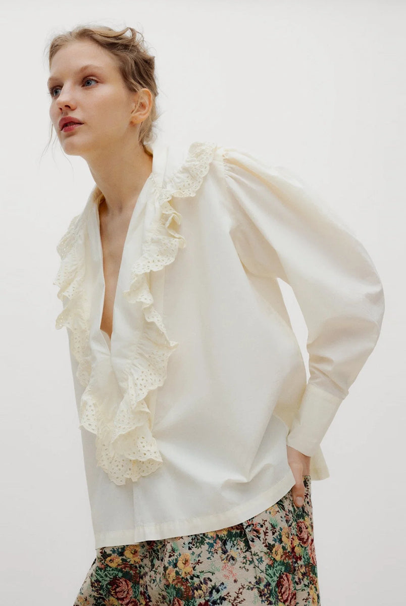 Romantyczna bluzka Vega TNS Whisper White wykonana z miękkiej, przewiewnej bawełny. Wyróżnia się swobodnym krojem oraz eleganckim dekoltem w kształcie litery V, wykończonym delikatnymi falbanami, które dodają całości faktury i ponadczasowej kobiecości. Delikatnie marszczone ramiona oraz obszerne długie rękawy zakończone dopasowanymi mankietami nadają sylwetce wdzięku. Bluzka doskonale sprawdzi się w codziennych stylizacjach, jak i podczas bardziej uroczystych okazji.
-Dekolt w kształcie litery V
-Delikatn