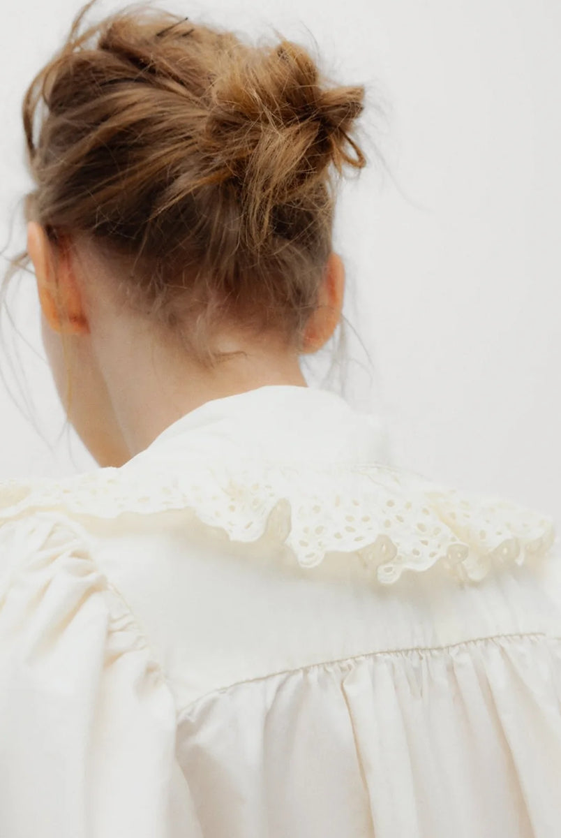 Romantyczna bluzka Vega TNS Whisper White wykonana z miękkiej, przewiewnej bawełny. Wyróżnia się swobodnym krojem oraz eleganckim dekoltem w kształcie litery V, wykończonym delikatnymi falbanami, które dodają całości faktury i ponadczasowej kobiecości. Delikatnie marszczone ramiona oraz obszerne długie rękawy zakończone dopasowanymi mankietami nadają sylwetce wdzięku. Bluzka doskonale sprawdzi się w codziennych stylizacjach, jak i podczas bardziej uroczystych okazji.
-Dekolt w kształcie litery V
-Delikatn