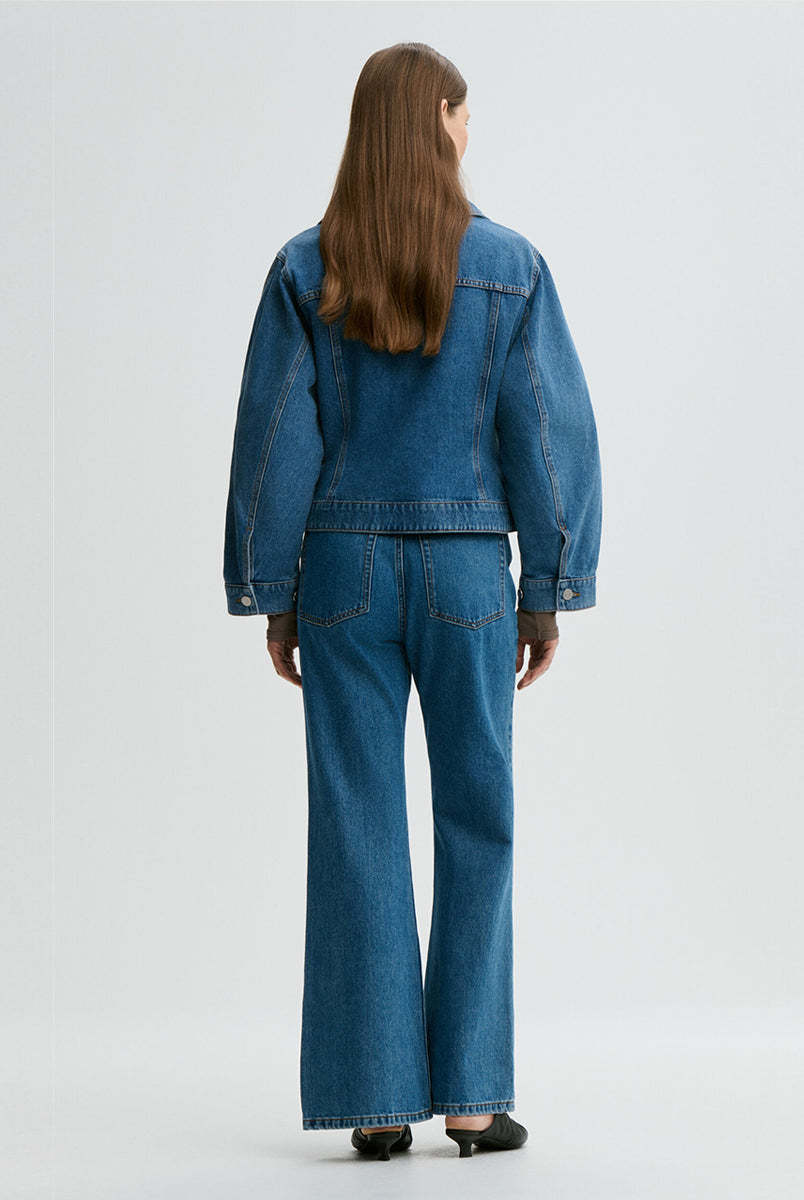 Klasyczna, jeansowa kurtka Villies Denim Blue By Malene Birger z zaokrąglonym kołnierzykiem, szerokimi rękawami i lekko dopasowanym krojem w talii. Długość kurtki sięga do bioder, co dobrze komponuje się ze spodniami z wysokim stanem. Posiada dwie, naszywane kieszenie z klapkami na piersiach. Zapinana na metalowe guziki. Wykonana z bawełny organicznej.
-Klasyczny krój
-Lekko taliowana
-Zamów w swoim standardowym rozmiarze