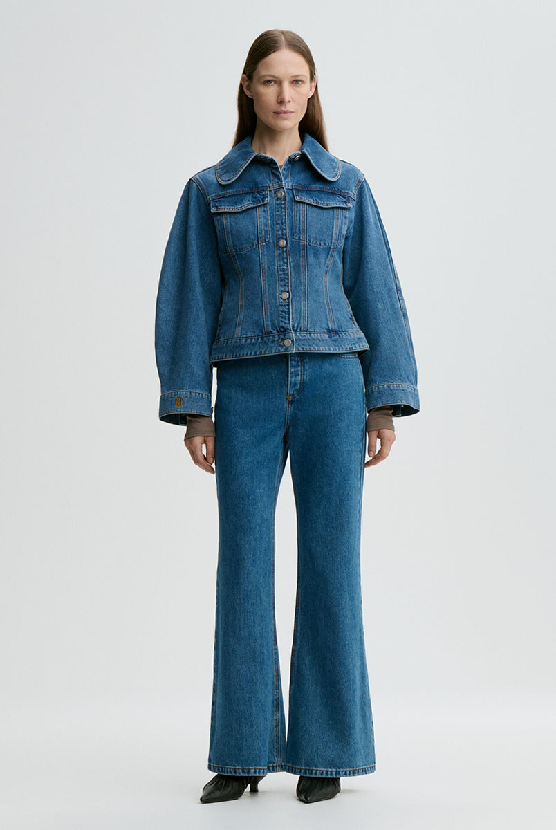 Klasyczna, jeansowa kurtka Villies Denim Blue By Malene Birger z zaokrąglonym kołnierzykiem, szerokimi rękawami i lekko dopasowanym krojem w talii. Długość kurtki sięga do bioder, co dobrze komponuje się ze spodniami z wysokim stanem. Posiada dwie, naszywane kieszenie z klapkami na piersiach. Zapinana na metalowe guziki. Wykonana z bawełny organicznej.
-Klasyczny krój
-Lekko taliowana
-Zamów w swoim standardowym rozmiarze