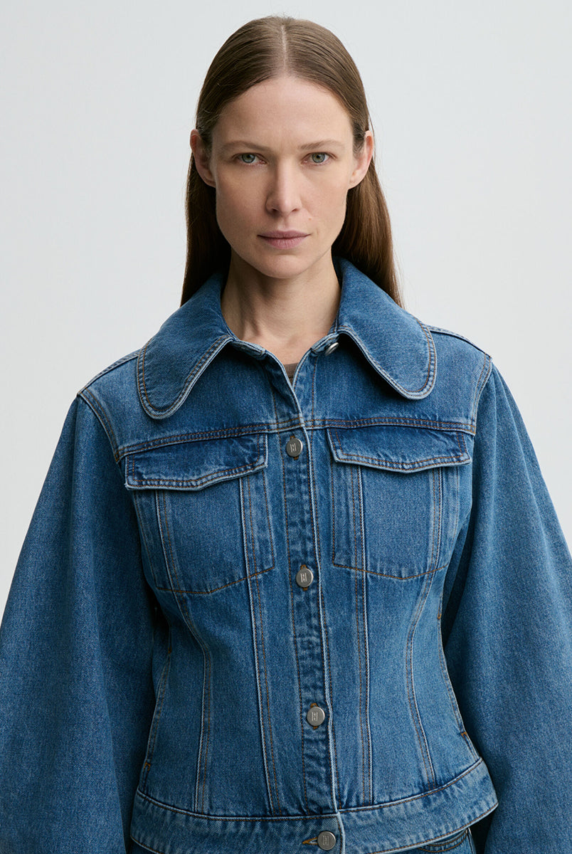 Klasyczna, jeansowa kurtka Villies Denim Blue By Malene Birger z zaokrąglonym kołnierzykiem, szerokimi rękawami i lekko dopasowanym krojem w talii. Długość kurtki sięga do bioder, co dobrze komponuje się ze spodniami z wysokim stanem. Posiada dwie, naszywane kieszenie z klapkami na piersiach. Zapinana na metalowe guziki. Wykonana z bawełny organicznej.
-Klasyczny krój
-Lekko taliowana
-Zamów w swoim standardowym rozmiarze