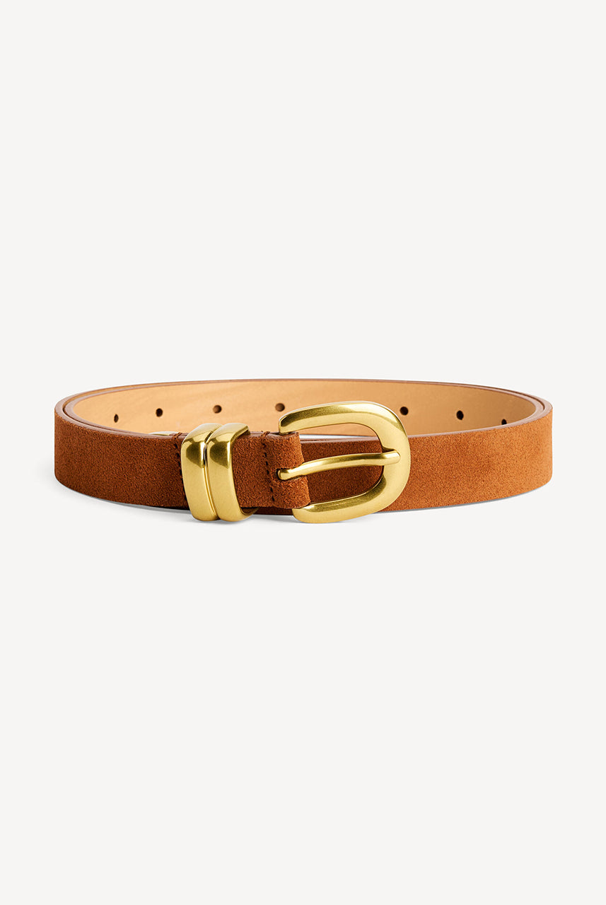 Zamszowy, cienki, klasyczny pasek Zoilo Suede Brown Patina By Malene Birger w brązowym kolorze. Posiada grubą, złotą sprzączkę. Idealny do sukienki i spodni stanem. 