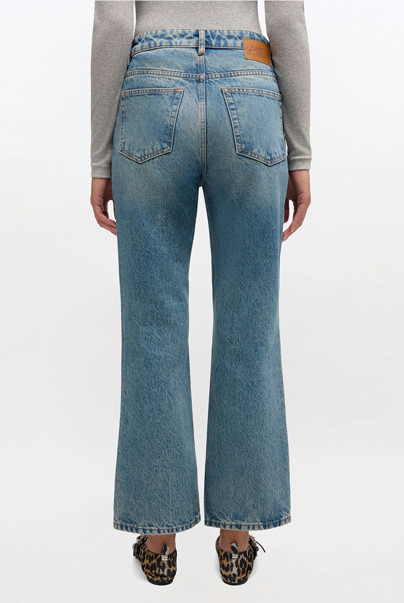 iebieskie jeansy z efektem sprania w stylu vintage Betzy GANNI Mid Blue Vintage ze średnim stanem i skróconą, lekko rozszerzaną u dołu nogawką. Dopasowane na biodrach i udach. Posiadają 5 kieszeni i niewielką naszywkę z logo GANNI na lewej, tylnej kieszeni. Wykonane z bawełny organicznej.
-Wysoki stan
-Miękka, bawełniana tkanina
-Skrócona, rozszerzana nogawka
-Zamów spodnie w swoim normalnym rozmiarze