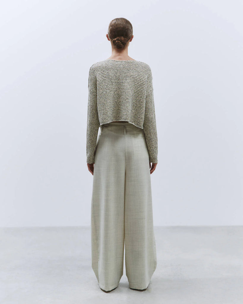 Cienkie, wełniane spodnie garniturowe z zakładkami. Posiadają wysoki stan i szeroką, prostą nogawkę. Spodnie mają dwie, boczne kieszenie.