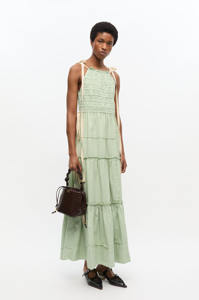 Niewielka, ciemnobrązowa torebka Bou Bucket 6697 GANNI o teksturze skóry krokodyla z plecionym uchwytem oraz regulowanym, odpinanym paskiem.