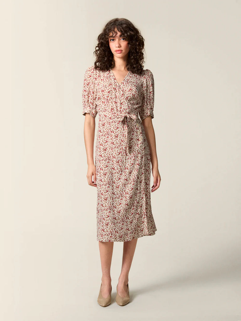 Zwiewna, kopertowa sukienka w kwiatowy print Rosalina Rouje z krótkimi, bufiastymi rękawami i trójkątnym dekoltem. Dopasowana i wiązana w talii za pomocą paska. Sukienka ma długość za kolana. 