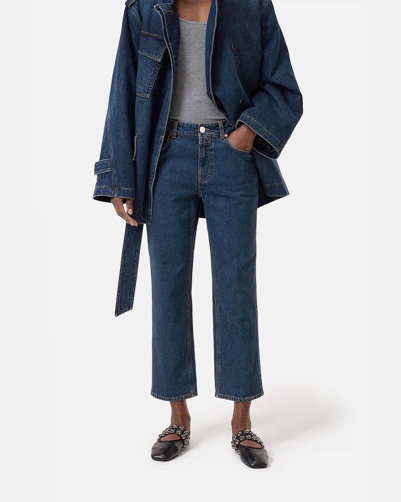 Granatowe jeansy Milo marki CLOSED ze średnim stanem i prostą, luźną i skróconą nogawką. Przylegające w biodrach. Spodnie mają pięć kieszeni. Zapinane na guzik i zamek błyskawiczny. Przy rozporku posiadają niewielką, charakterystyczną dla marki naszywkę z logo CLOSED. 