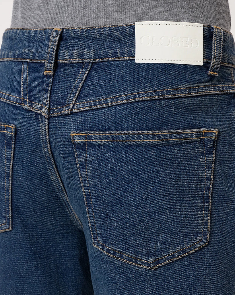 Granatowe jeansy Milo marki CLOSED ze średnim stanem i prostą, luźną i skróconą nogawką. Przylegające w biodrach. Spodnie mają pięć kieszeni. Zapinane na guzik i zamek błyskawiczny. Przy rozporku posiadają niewielką, charakterystyczną dla marki naszywkę z logo CLOSED. 