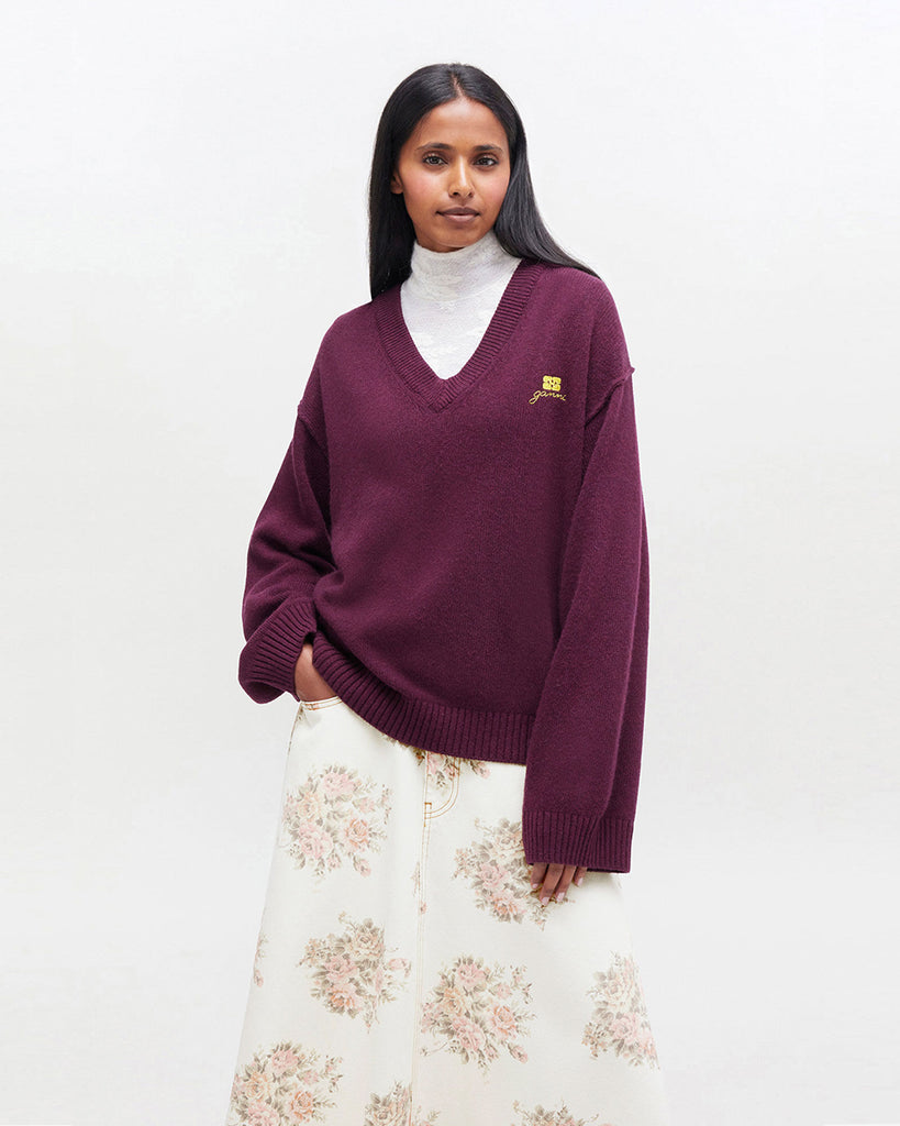 Luźny, burgundowy sweter 2590 Burgundy marki GANNI z dekoltem w serek i długimi rękawami. Wykończony ściągaczami. Z lewej strony, na piersi posiada niewielkie, haftowane logo marki. Wykonany z dzianiny z wełną. Zestaw go z ulubioną spódnicą lub klasycznymi jeansami.