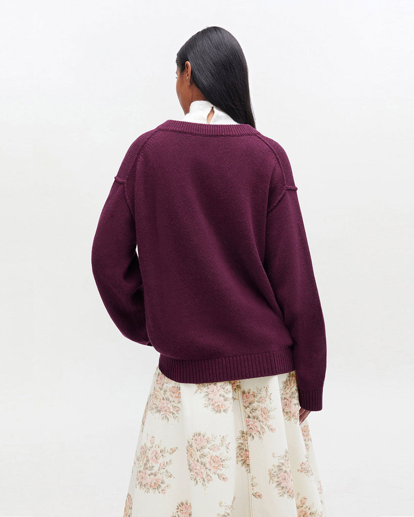 Luźny, burgundowy sweter 2590 Burgundy marki GANNI z dekoltem w serek i długimi rękawami. Wykończony ściągaczami. Z lewej strony, na piersi posiada niewielkie, haftowane logo marki. Wykonany z dzianiny z wełną. Zestaw go z ulubioną spódnicą lub klasycznymi jeansami.