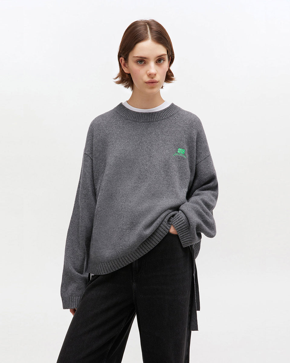 Szary, oversizowy sweter 2632 Charcoal Grey marki GANNI z okrągłym dekoltem i długimi rękawami. Posiada niewielkie logo marki na lewej piersi. Zakończony ściągaczami i wiązaniami u dołu. Wykonany z dzianiny z wełną.&nbsp;
