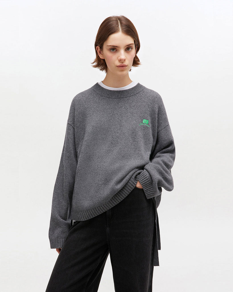 Szary, oversizowy sweter 2632 Charcoal Grey marki GANNI z okrągłym dekoltem i długimi rękawami. Posiada niewielkie logo marki na lewej piersi. Zakończony ściągaczami i wiązaniami u dołu. Wykonany z dzianiny z wełną.&nbsp;
