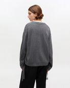 Szary, oversizowy sweter 2632 Charcoal Grey marki GANNI z okrągłym dekoltem i długimi rękawami. Posiada niewielkie logo marki na lewej piersi. Zakończony ściągaczami i wiązaniami u dołu. Wykonany z dzianiny z wełną.&nbsp;
