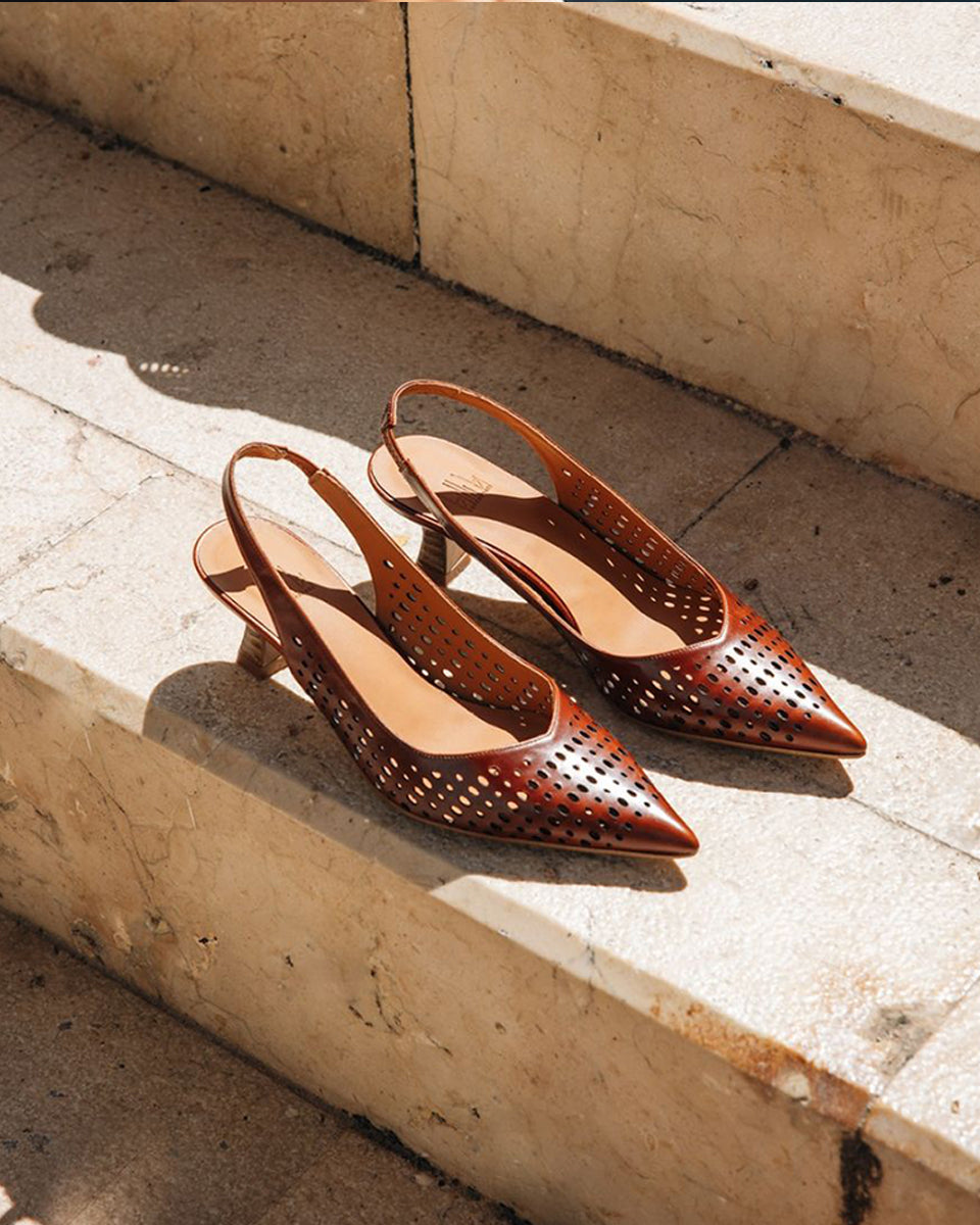 Ręcznie wykonane czółenka typu sling back 9459 Brown Billi Bi Copenhagen z brązowej, gładkiej skóry. Mają noski w szpic, co optycznie wydłuża stopę. Charakterystycznym elementem jest ażurowa tekstura. Buty mają niski, stabilny obcas z fakturą przypominającą jasne drewno. Idealnie sprawdzą się na codzień.&nbsp;

-Buty mają standardową rozmiarówkę. Zamów je w rozmiarze jaki normalnie nosisz
