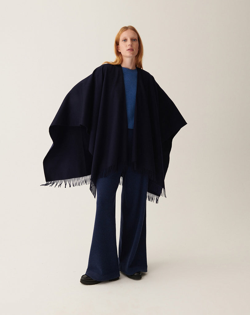 Ponadczasowe Ponczo A270 Marine w granatowym kolorze tkane ze 100% kaszmiru. Posiada wykończenie z frędzlami. Idealne jako uzupełnienie jesiennych stylizacji.&nbsp;