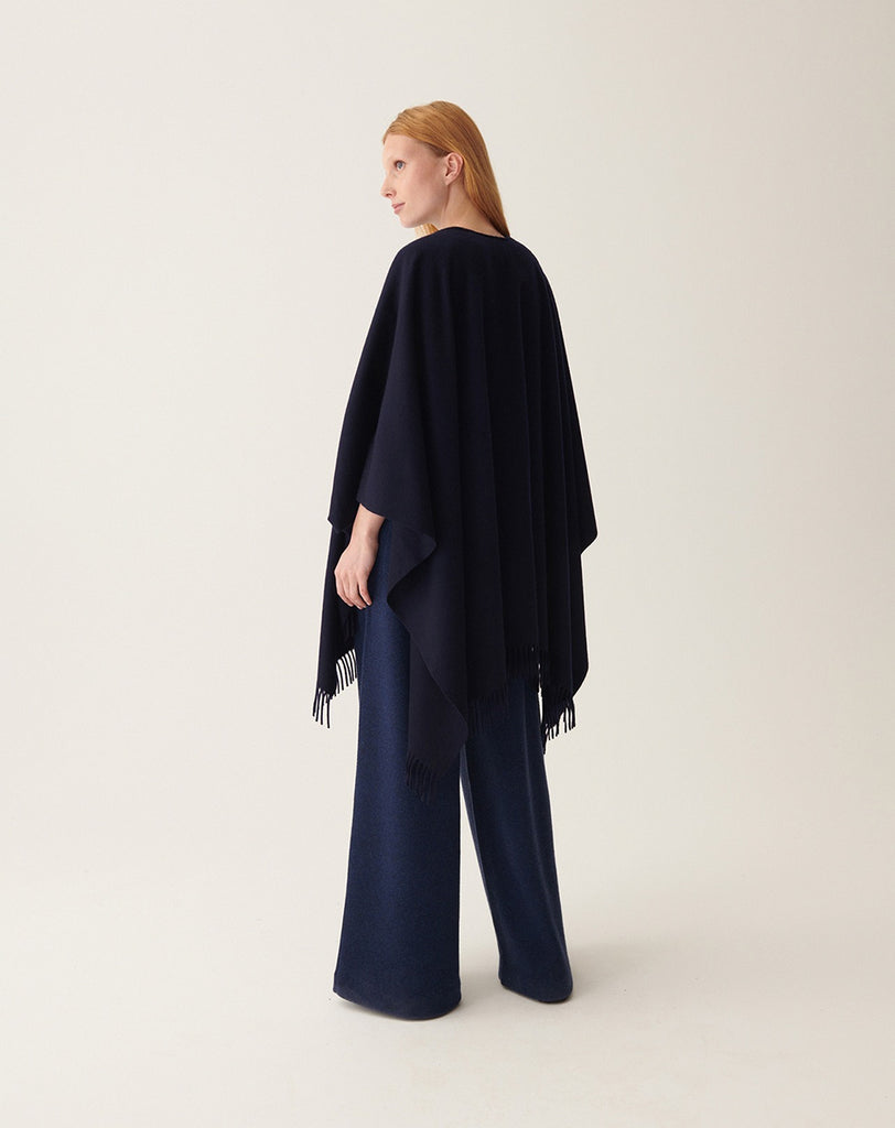Ponadczasowe Ponczo A270 Marine w granatowym kolorze tkane ze 100% kaszmiru. Posiada wykończenie z frędzlami. Idealne jako uzupełnienie jesiennych stylizacji.&nbsp;