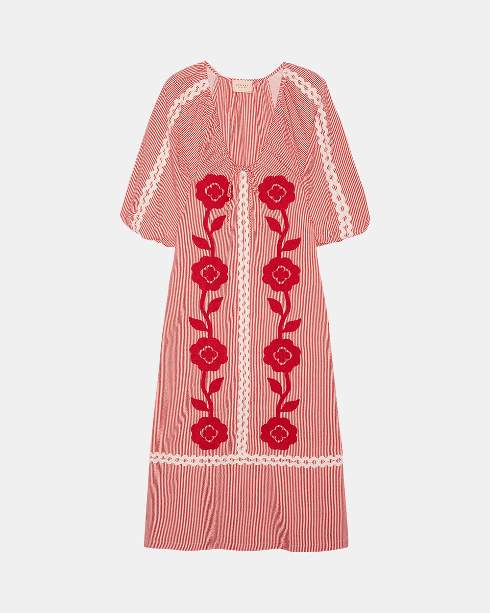 Szeroka, luźna sukienka Abelone Red Flower marki SISSEL EDELBO z obszernymi rękawami typu raglan z elastycznymi otworami i szerokim dekoltem w serek, który ściągany jest regulowanym sznurkiem. Posiada miękką podszewkę, która nadaje bufiasty kształt. Ozdobiona jest wyrazistym, kwiatowym haftem oraz szerokimi, zygzakowatymi taśmami. Wykonana w 100% z jakościowej bawełny organicznej.&nbsp;

-Luźny, szeroki krój

-Kwiatowy haft

-Ściągany dekolt w serek

-ONE SIZE