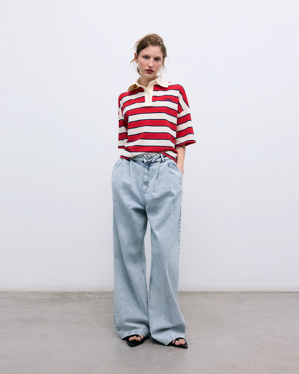 Krótki, pudełkowy t-shirt polo Acacia Polo Tulip Red z kontrastowymi paskami. Posiada kołnierzyk, opadające ramiona i krótki, szeroki rękaw o długości do łokci. Pod szyją zapinany na guziki. Nad lewą piersią posiada niewielką naszywkę z logo marki. Wykonany z bawełny.

-Luźny fason

-100% bawełna

-Zamów w swoim standardowym rozmiarze
