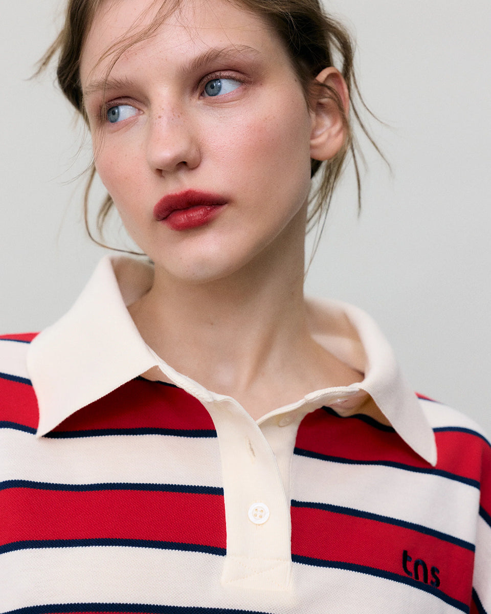 Krótki, pudełkowy t-shirt polo Acacia Polo Tulip Red z kontrastowymi paskami. Posiada kołnierzyk, opadające ramiona i krótki, szeroki rękaw o długości do łokci. Pod szyją zapinany na guziki. Nad lewą piersią posiada niewielką naszywkę z logo marki. Wykonany z bawełny.

-Luźny fason

-100% bawełna

-Zamów w swoim standardowym rozmiarze