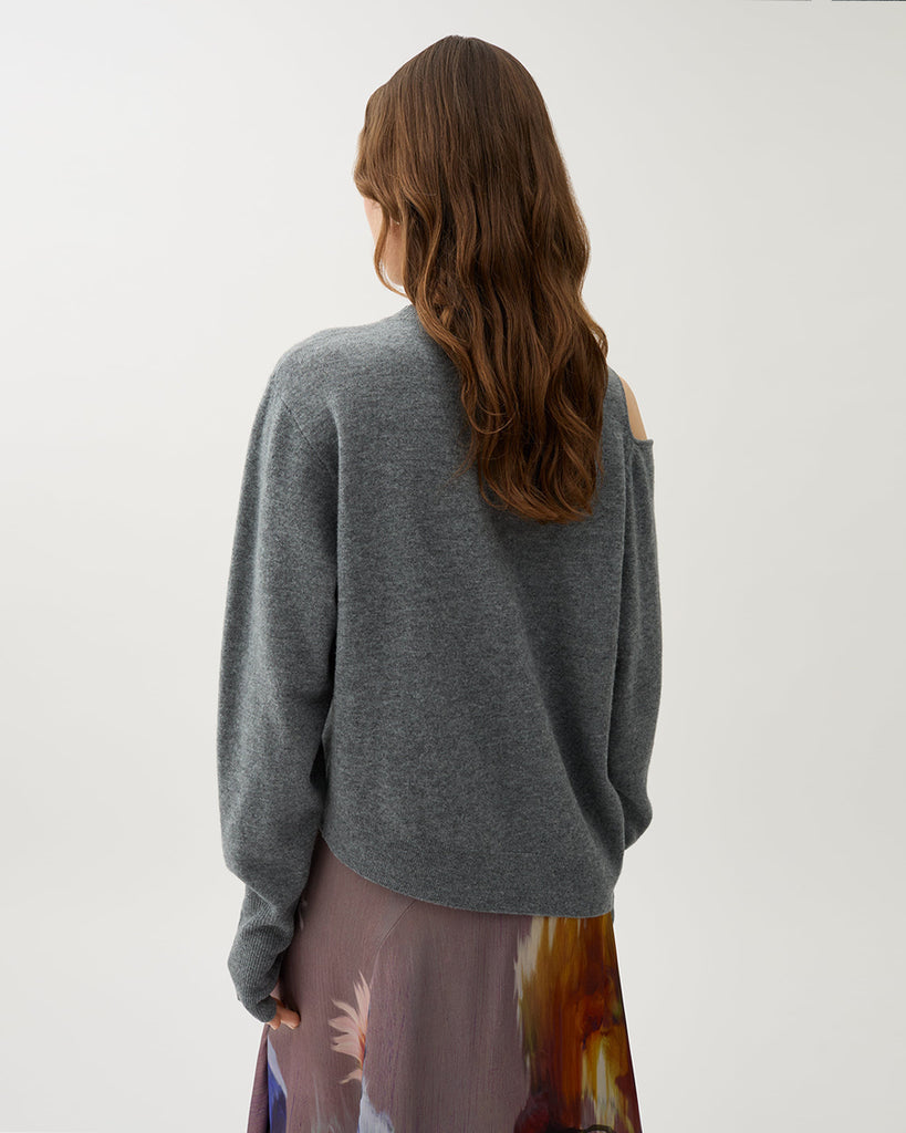 Cienki, szary sweter Acer Light Grey Melang z wycięciem na jednym ramieniu i otworami na kciuki w wydłużonych rękawach. Ma asymetryczny dół, który pozwala na różnorodne stylizacje z dopasowanymi spodniami lub spódnicą. Wykonany z miękkiej dzianiny z wełny merino.&nbsp;