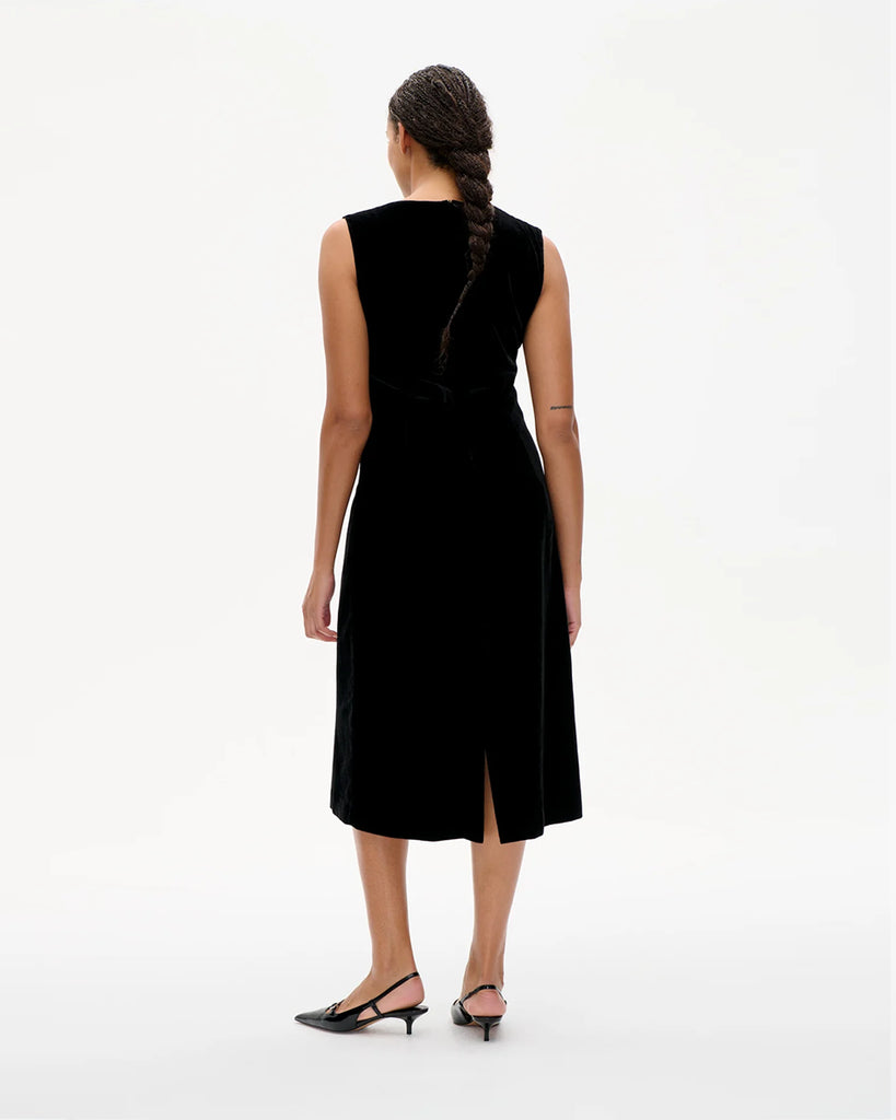 Aksamitna, dopasowana sukienka Ajka Black Velvet bez rękawów. Zdobiona dekoltem w serek z kokardkami. Zapinana na zamek z tyłu. Wykonana z miękkiej mieszanki wiskozy. Długość midi. Idealna romantyczna i zarazem nowoczesna propozycja na wyjątkowe okazje.&nbsp;