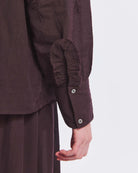 Haftowana, bawełniana bluzka Albertine Antik Batik Burgundy z długimi rękawami i niewielką stójką, która wykończona jest falbanką. Posiada ażurowy haft z przodu i na rękawach. Ma kryte zapięcie na guziki. Ta zwiewna bluzka, inspirowana modą wiktoriańską może być noszona samodzielnie lub w komplecie z pasującą spódnicą, tworząc romantyczną stylizację.&nbsp;