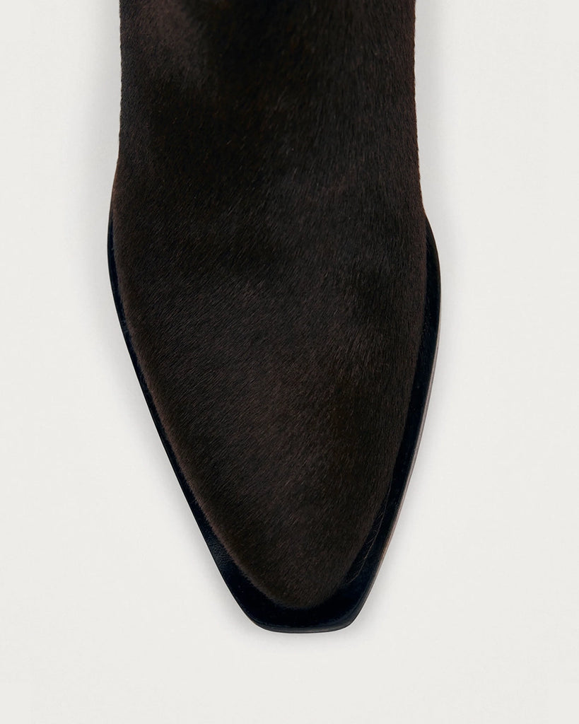 Brązowe, skórzane botki ALOHAS Syd Soft Dark Brown z lekko spiczastym noskiem i cholewką sięgającą tuż nad kostkę. Z boku widoczne są subtelne przeszycia i małe szlufki u góry, które ułatwiają zakładanie. Wykonane z naturalnej skóry z włosiem.