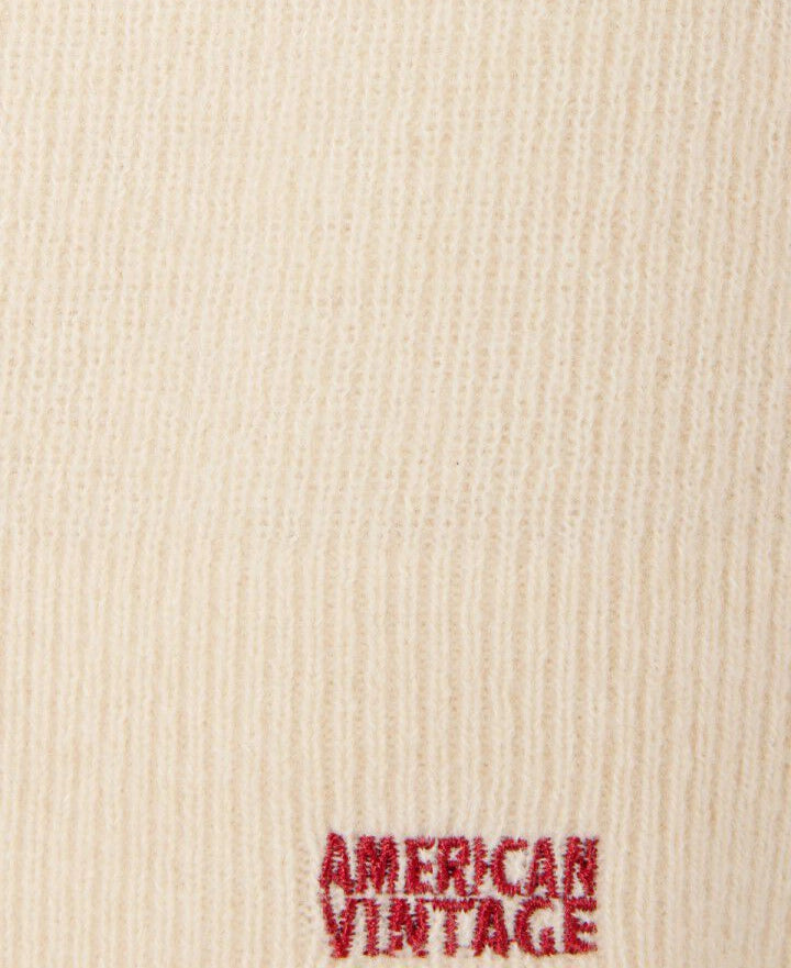 Kremowa balaclava RAXOW American Vintage z cienkiej i ciepłej dzianiny z wełną i kaszmirem. Posiada czerwony haft z logo marki.