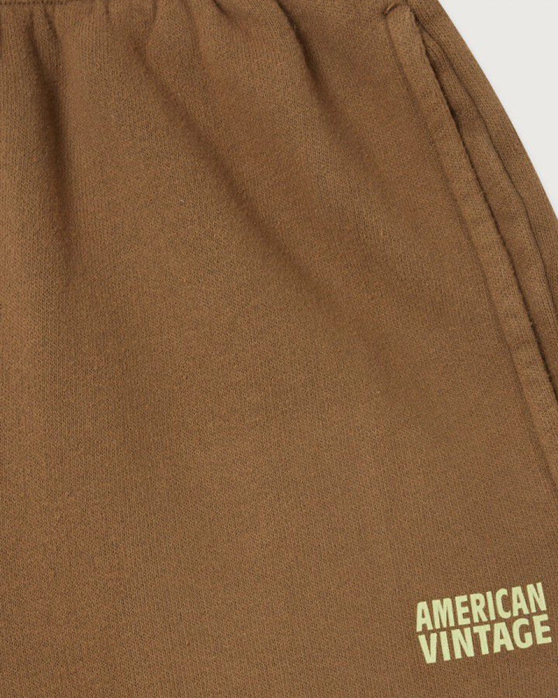 Luźne, brązowe spodnie dresowe IZUBIRD American Vintage z wysokim stanem i elastyczną talią. Spodnie mają luźną, zwężaną nogawkę wykończoną ściągaczem. 