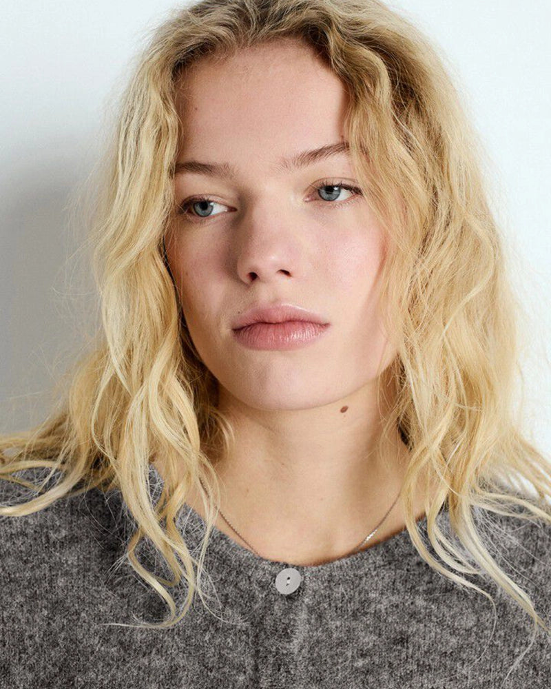 Krótki, kremowy kardigan VITOW American Vintage o pudełkowym fasonie. Posiada okrągły dekolt i opadające ramiona. Zapinany na guziki z imitacji masy perłowej. Wykonany z cienkiej i bardzo miękkiej dzianiny z wełną i alpaką. To klasyczny model, który musi znaleźć się w każdej szafie. Pasuje dosłownie do wszystkiego - ulubionych jeansów, zwiewnej spódnicy, długiej sukienki czy spodni garniturowych