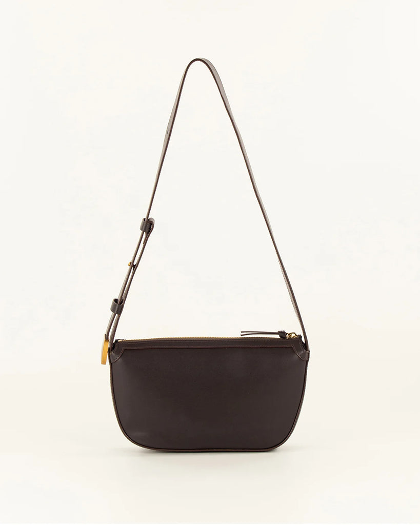 Brązowa skórzana torebka Amo Deep Coffee typu baguette marki Sessun z ręcznie plecionym panelem z przodu. Posiada kieszeń centralną z dodatkową kieszenią naszytą i regulowany pasek na ramię, z zapięciem na ćwieki oraz metalowym, złotym zakończeniem z logo marki.