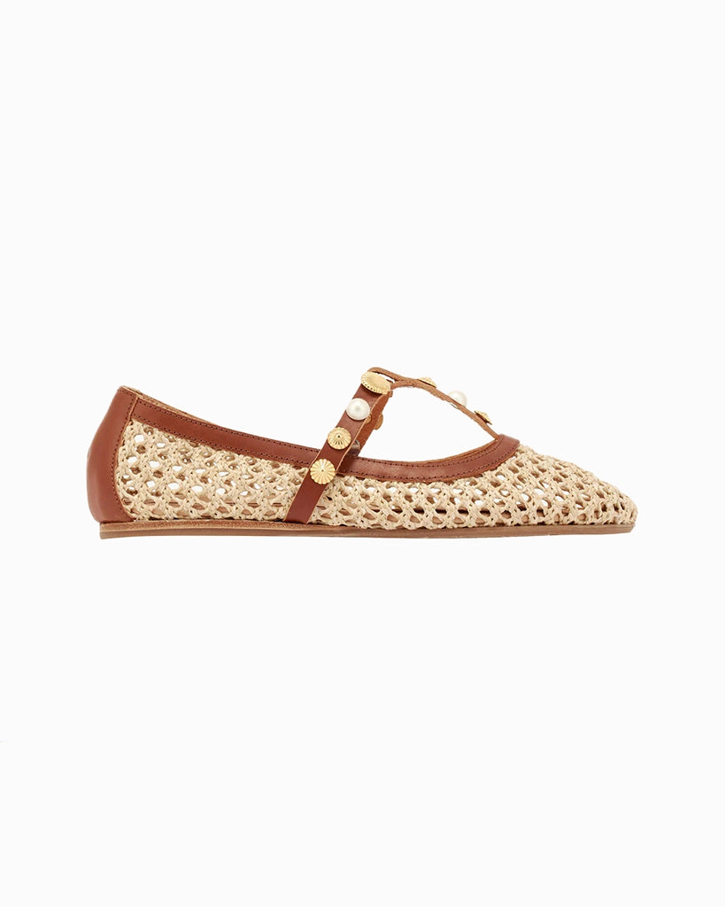 Plecione, ażurowe baletki na płaskiej podeszwie Aerati Ancient Greek Sandals z cienkimi, skórzanymi, skrzyżowanymi paskami dekorowanymi biżuteryjnymi aplikacjami z motywami muszelek i sztucznych pereł. Wykonane z rafii i miękkiej skóry naturalnej.