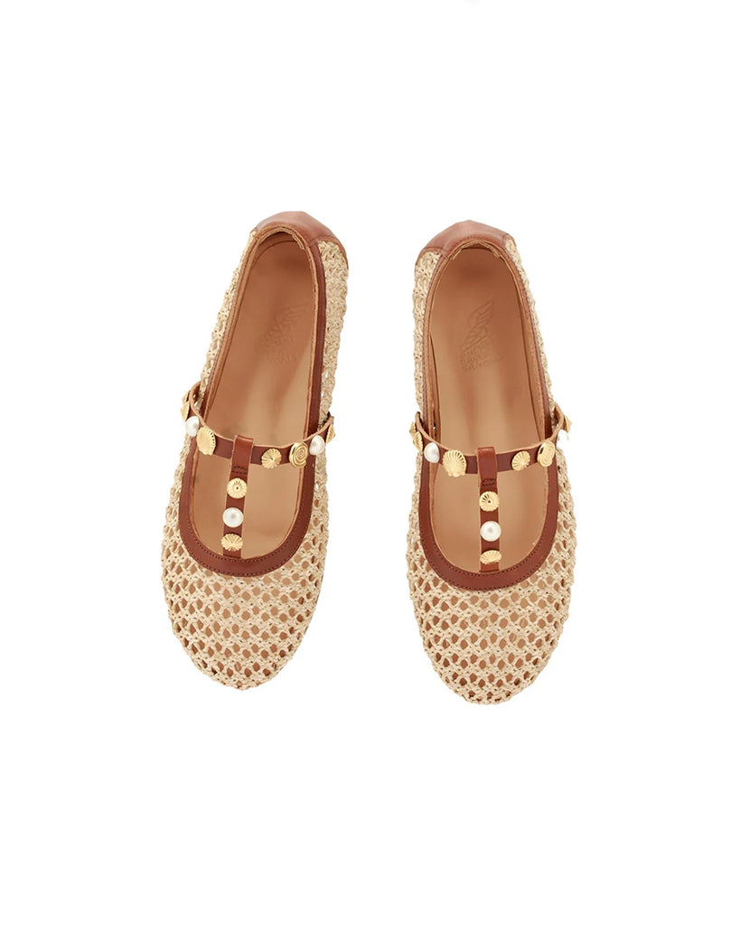 Plecione, ażurowe baletki na płaskiej podeszwie Aerati Ancient Greek Sandals z cienkimi, skórzanymi, skrzyżowanymi paskami dekorowanymi biżuteryjnymi aplikacjami z motywami muszelek i sztucznych pereł. Wykonane z rafii i miękkiej skóry naturalnej.