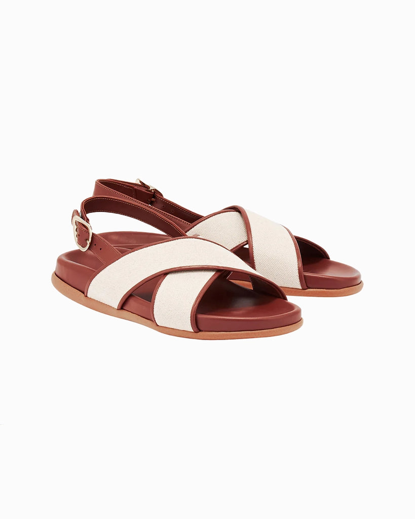Skórzane sandały Ikesia Ancient Greek Sandals na płaskiej, profilowanej od wewnętrznej strony podeszwie z szerokimi, skrzyżowanymi paskami na górze obszytymi naturalną, płócienną tkaniną.