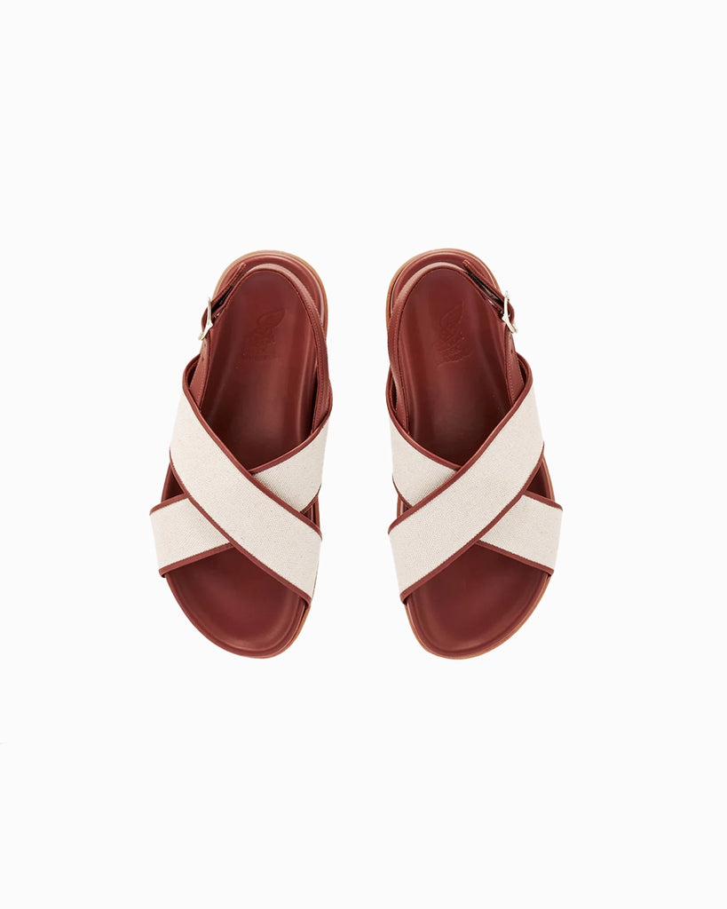 Skórzane sandały Ikesia Ancient Greek Sandals na płaskiej, profilowanej od wewnętrznej strony podeszwie z szerokimi, skrzyżowanymi paskami na górze obszytymi naturalną, płócienną tkaniną.