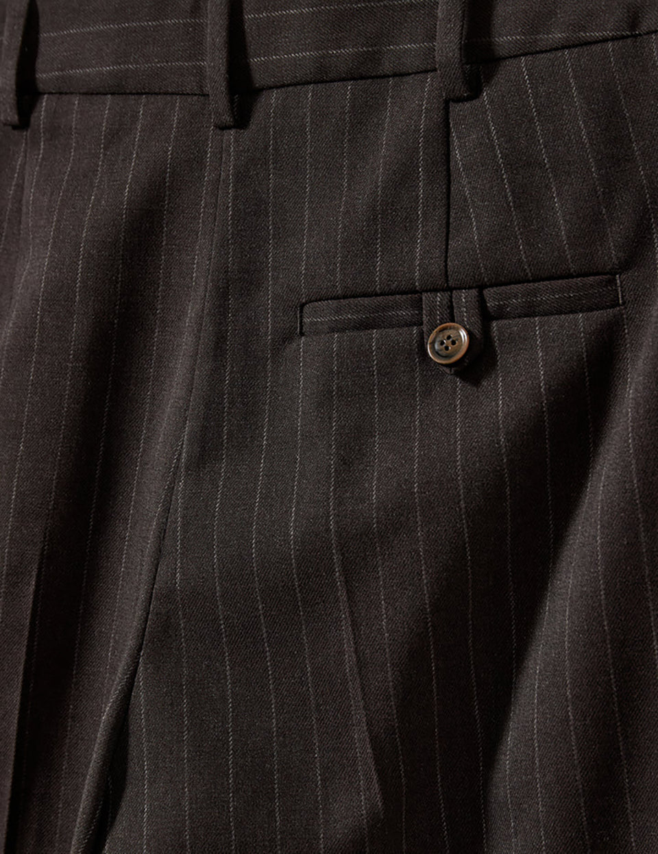 Bardzo długie, luźne, eleganckie spodnie Andora Dark Brown z wysokim stanem i bardzo szerokimi, prostymi nogawkami. Posiadają głębokie plisy z przodu. Mają klasyczne kieszenie boczne w szwach, kieszeń tylną zapinaną na guzik i szlufki na pasek. Zapinane na haftkę i guzik. Ozdobione są subtelnymi, pionowymi prążkami na ciemnobrązowym tle.&nbsp;

-Luźny krój

-Szerokie nogawki

-Spodnie mają długość ,floor-sweeping'. Są bardzo długie, niemal zakrywające buty.&nbsp;
