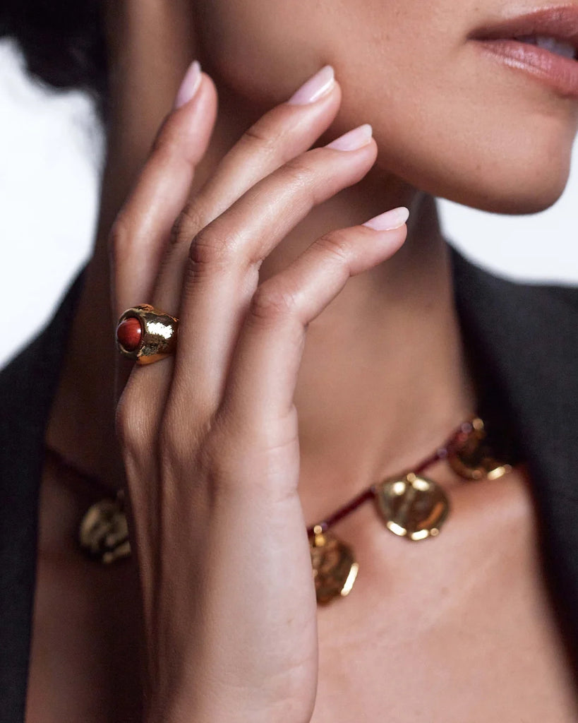 Efektowny, pozłacany sygnet Cherry on top Anni Lu z chropowatą fakturą i z dużym oczkiem z czerwonego jaspisu.